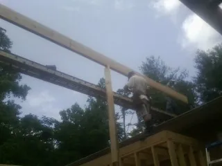 Carpenter setting a ridge beam over a new addition frame — Ice Dam Removal by Roofing Brothers in Battle Lake