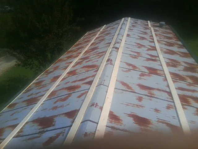 Rusted metal roof panels with new wood purlins before replacement — Storm Damage Roof Repair in Battle Lake by Roofing Brothers
